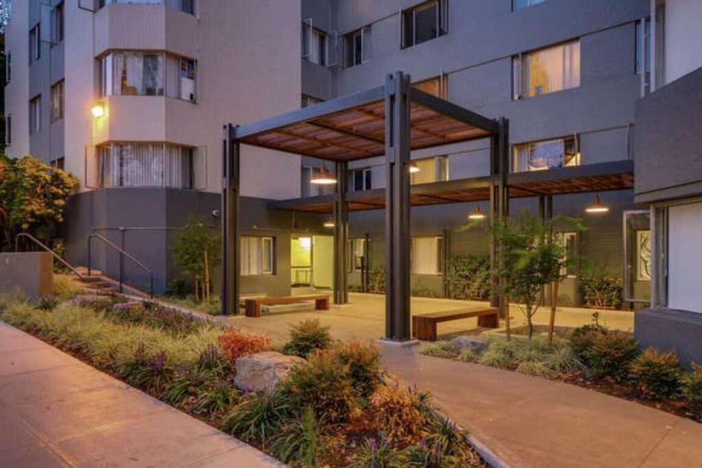 Building entrance with shaded seating and garden landscaping